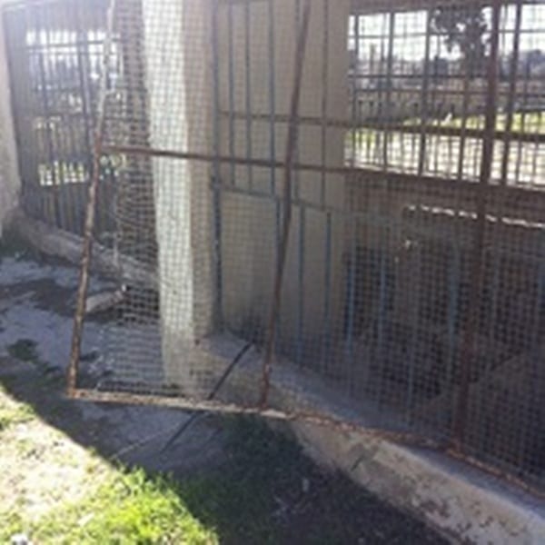 The chapel’s wire mesh gate, broken into
